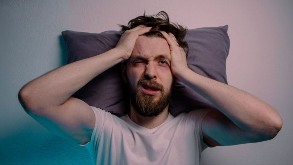 Man showing stress and fatigue caused by sleep deprivation