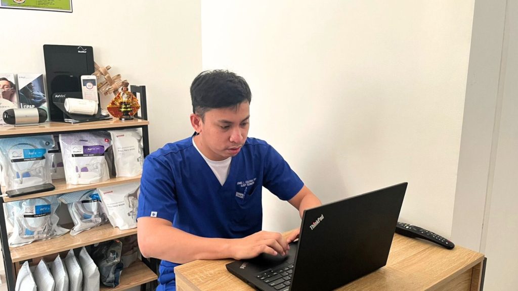 Jomel Lorca Celestial reviewing CPAP data at clinic desk